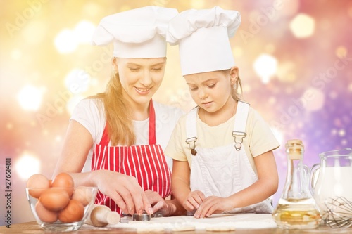 Portrait of adorable little girl and her mother baking together