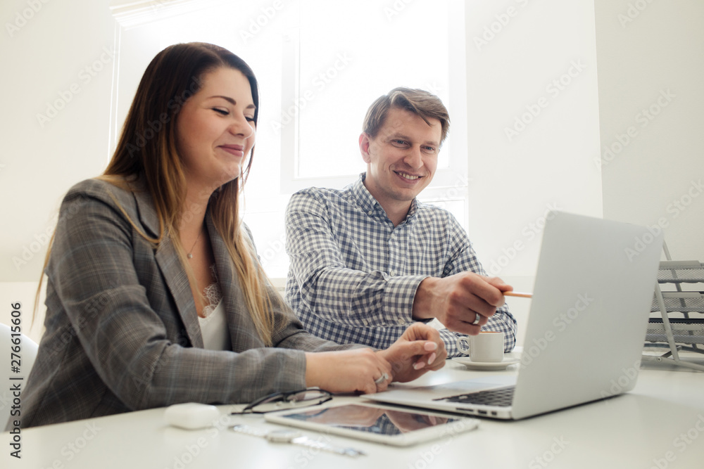 younger girl and man working in the office at the table younger girl and man working in the office at the table