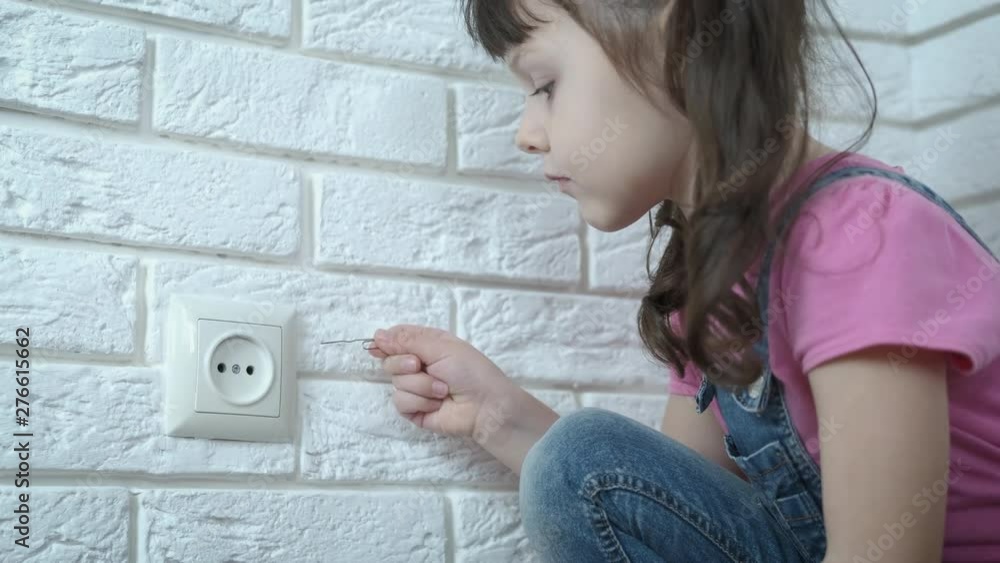 A child with electricity. A little girl without parental supervision wants to shove a wire into the socket. A child with electricity. A little girl without parental supervision wants to shove a wire into the socket.