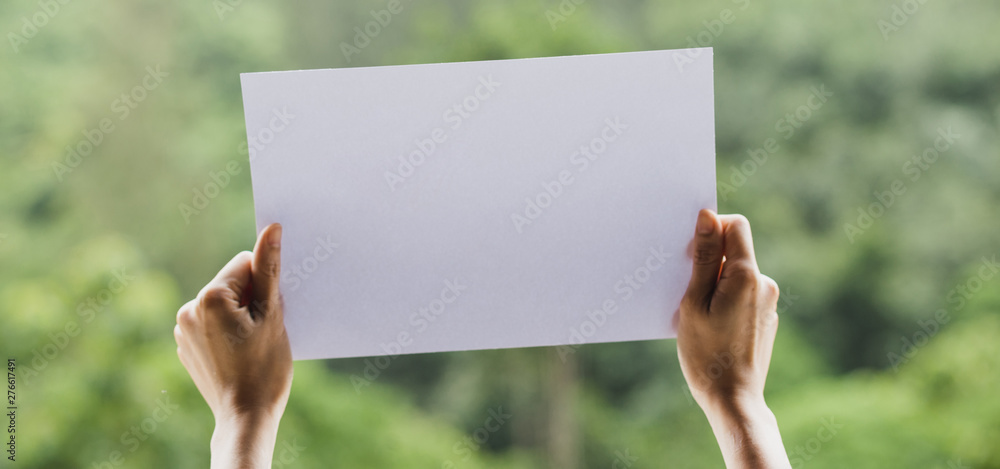 Show business paper in hand on nature background Show business paper in hand on nature background