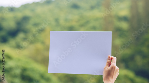 Show business paper in hand on nature background