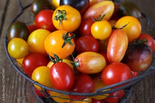 cherry tomatoes are different varieties in the basket  small tomatoes of different colors and types.