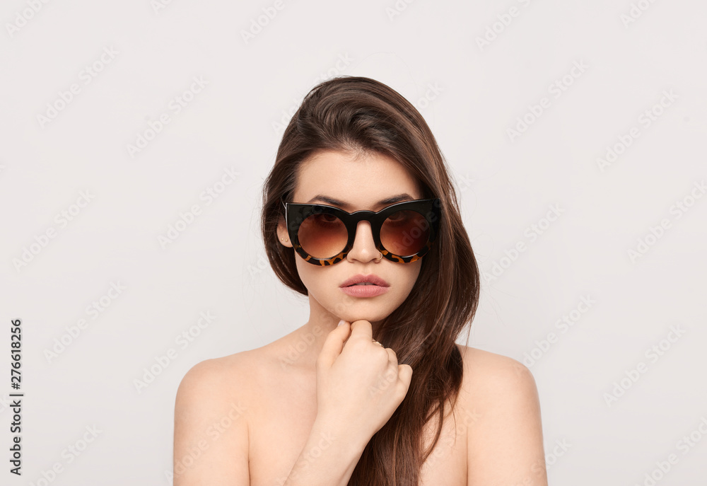 Close up studio shot of beautiful fashion young woman model with long hair looking at camera . while posing against clean white blank copy space wall for your content Close up studio shot of beautiful fashion young woman model with long hair looking at camera . while posing against clean white blank copy space wall for your content