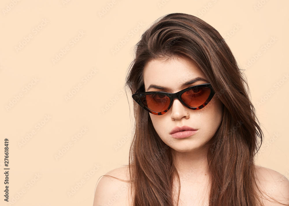 sunglasses girl, close up studio shot of beautiful fashion young woman model with long hair looking at camera . while posing against clean cream blank copy space wall for your content sunglasses girl, close up studio shot of beautiful fashion young woman model with long hair looking at camera . while posing against clean cream blank copy space wall for your content