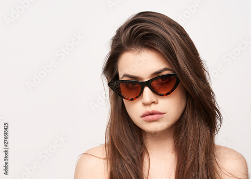 sunglasses girl, close up studio shot of beautiful fashion young woman model with long hair looking at camera . while posing against clean white blank copy space wall for your content