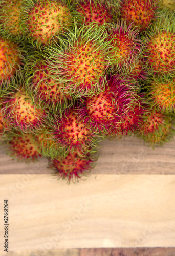 Many fresh rambutans are placed on the old wood