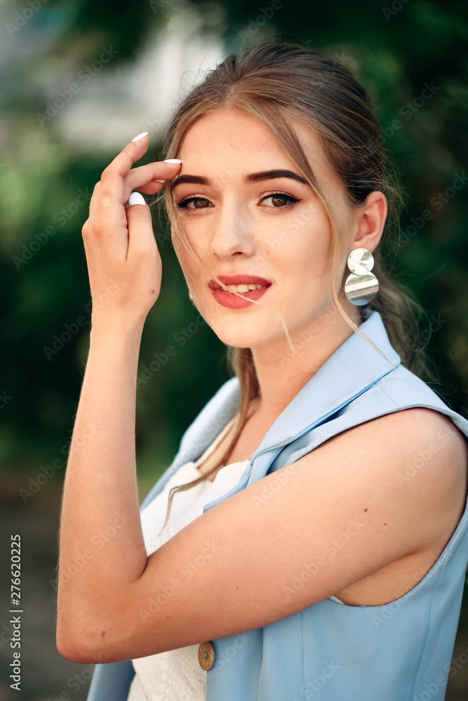 Gorgeous young model woman with perfect hair looking at camera posing in the city wearing classic costume. Gorgeous young model woman with perfect hair looking at camera posing in the city wearing classic costume.