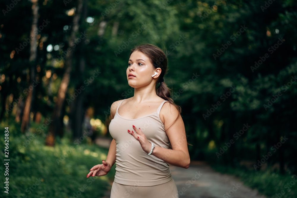 A young woman runner runs in a park in the park.