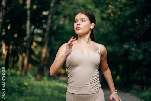 A young woman runner runs in a park in the park.