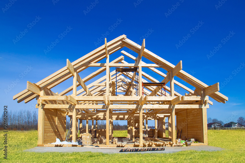 Frame house under construction. Construction site on a sunny day. House from laminated veneer timber. Remodeling of the cottage. The house wooden base. Houses to order. Production of wooden houses. Frame house under construction. Construction site on a sunny day. House from laminated veneer timber. Remodeling of the cottage. The house wooden base. Houses to order. Production of wooden houses.