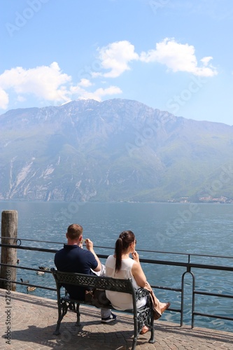 Young couple on vacation in front of lake and mountains 
