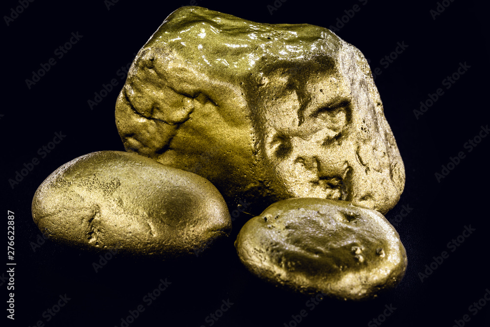 Gold nugget, large gold stone closeup isolated on black background. Concept of finance, luxury or wealth. Gold nugget, large gold stone closeup isolated on black background. Concept of finance, luxury or wealth.