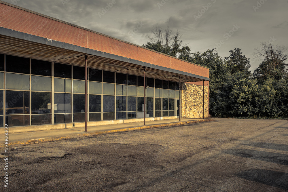 Long row of tall windows of an older brick office building sitting empty in midwestern suburb