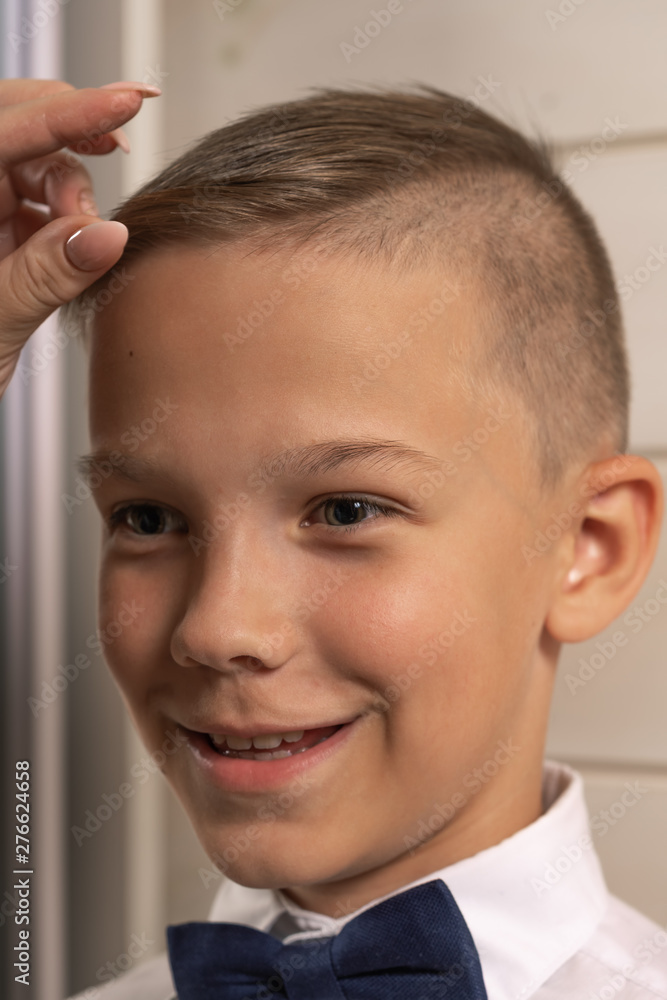 A 10-year-old boy prepares for school after a long summer break. Back to school. In front of the mirror. A 10-year-old boy prepares for school after a long summer break. Back to school. In front of the mirror.