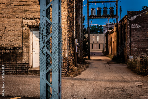 Fototapeta Naklejka Na Ścianę i Meble -  Steel beam in focus in front of vintage brick warehouse in small midwestern town