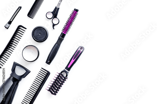 Combs, sciccors and pink hairdresser tools in beauty salon work desk on white background top view space for text