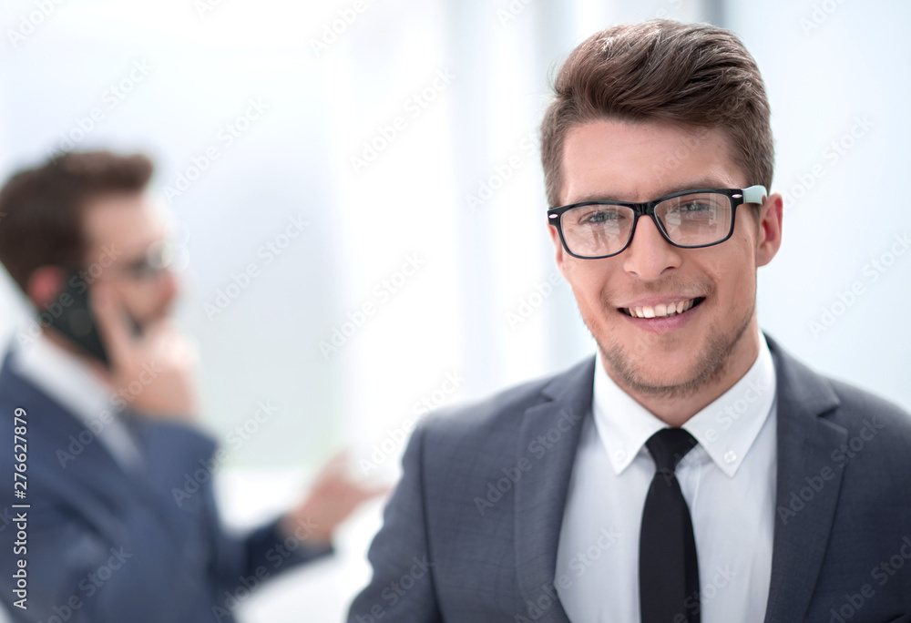 close up.smiling young businessman in the office background close up.smiling young businessman in the office background