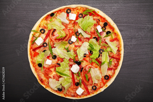 Tasty pizza with various flavored ingredients on a dark background