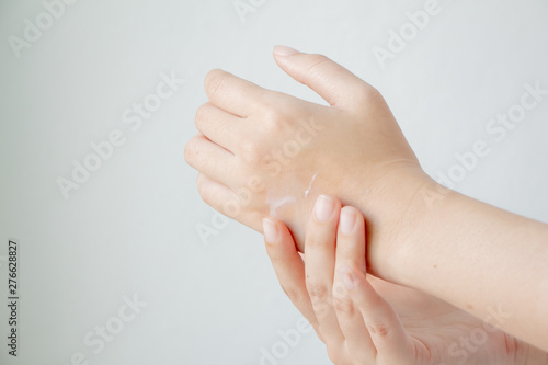 Woman hands applying hand cream moisturize the skin. The weather is cold.