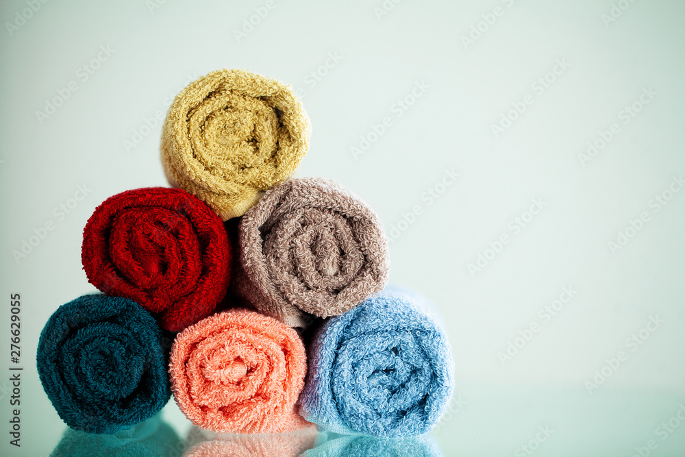 Colored towels on white table with copy space on bath room background Colored towels on white table with copy space on bath room background