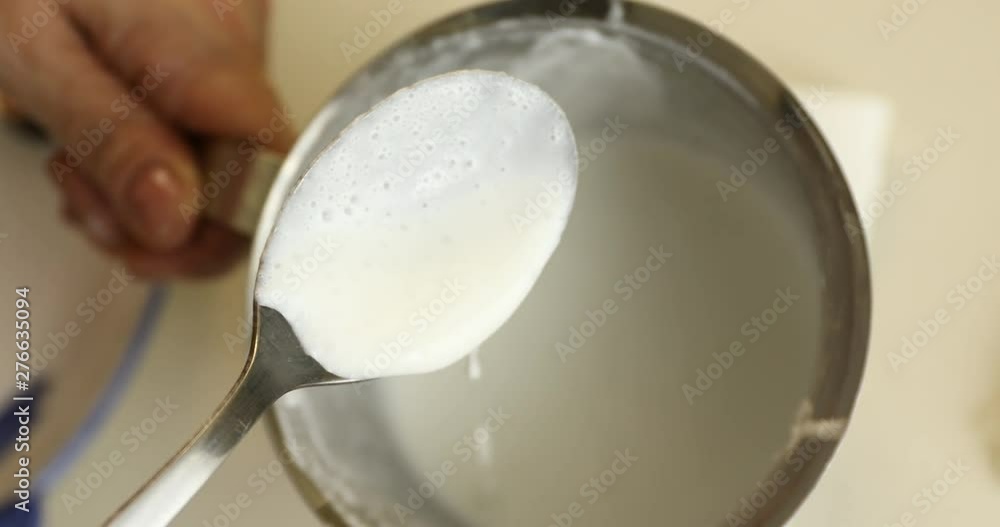 Checking concentration of milk foam with spoon Checking concentration of milk foam with spoon