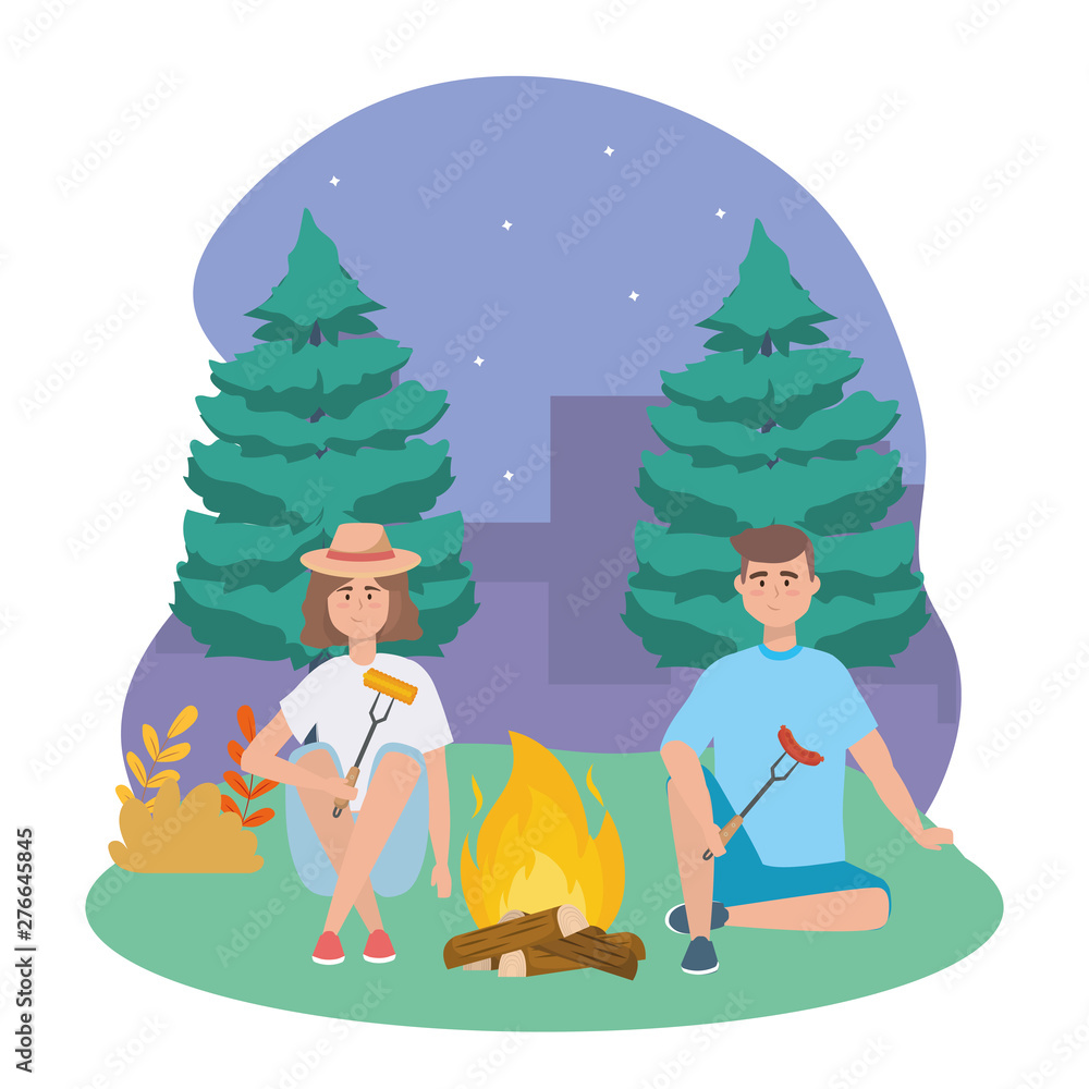 man and woman with wood fire and sausage with cob man and woman with wood fire and sausage with cob