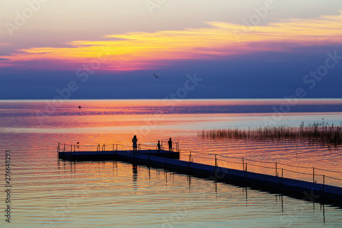 family on pontoon pier at sunset