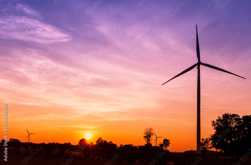Wind turbines electric power generator on sunset sky at agriculture field Wind turbines electric power generator on sunset sky at agriculture field