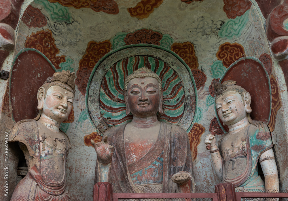 Sculpture of Maitreya Buddha and two attendant Bodhisattvas with colorful fresco in left niche at venrandah of Grotto 5 at Mount Maiji or Maijishan Grottoes, Tianshui, Gansu, China.