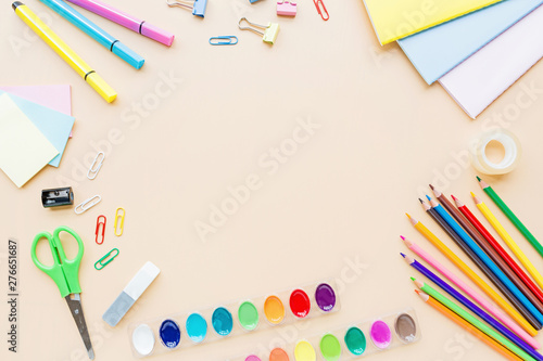 School supplies stationery, paints on pastel orange background, back to school concept with free copy space for text, modern elementary education. Kids desk, flat lay, overhead, top view, mockup.