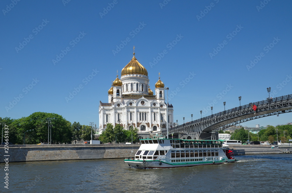 Summer view of the Cathedral of Christ the Saviour and the Patriarchal bridge. Pleasure boat floating on the Moscow-river. Moscow, Russia