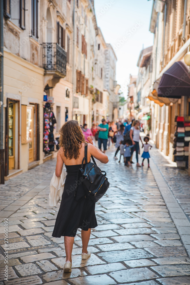 woman walking by small porec streets in croatia