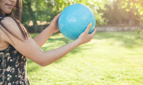 Woman soccer player holding soccer ball.