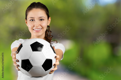 Soccer fan. Young beautiful woman holding soccer ball over isolated background © fotofabrika