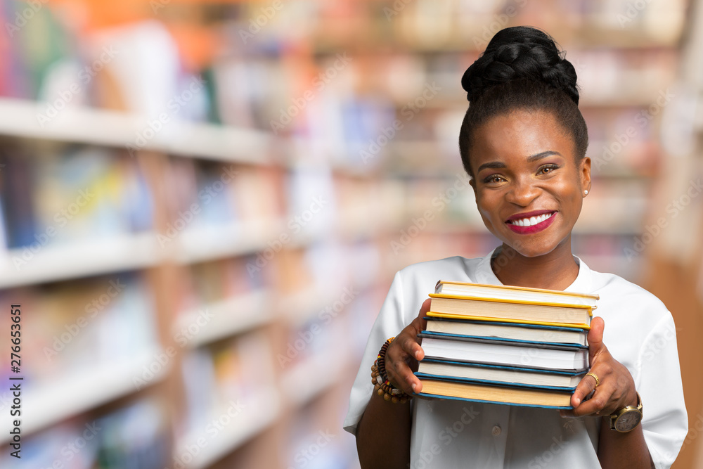 Portrait of a happy student girl or woman with books in library Portrait of a happy student girl or woman with books in library