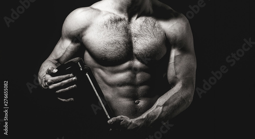 Sportsman hold dieting pill. Doping, anabolic, protein, steroid, sport vitamin, bodybuilder. Man with muscular body hold pill jar, sport. Muscles strong, muscular. Dieting, fitness. Black and white. photo