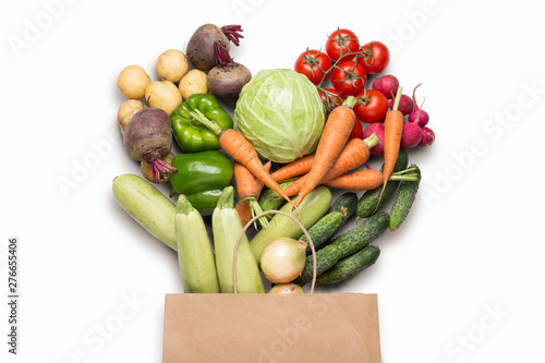 Fototapeta Naklejka Na Ścianę i Meble -  Paper shopping bag and fresh organic vegetables on a white background. Concept of buying farm vegetables, taking care of health, vegetarianism. Country style, Farm Fair. Flat lay, top view