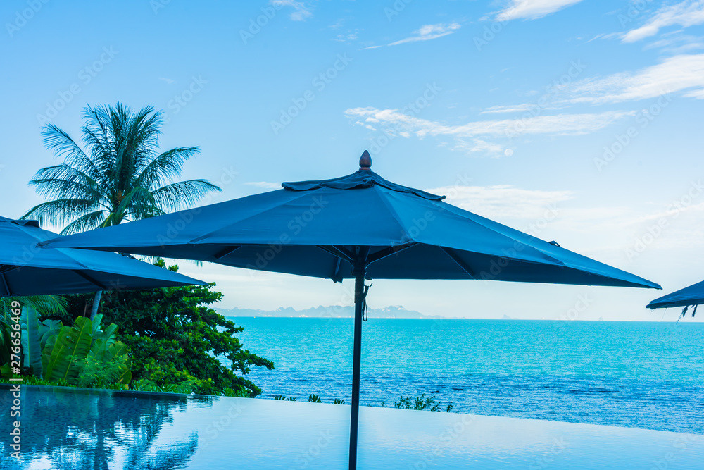 Umbrella and chair around beautiful luxury outdoor swimming pool with sea ocean view in hotel resort for holiday vacation travel