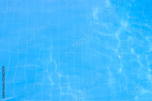 Water vibrations in the swimming pool with sun reflection. blue swimming pool surface, water background in swimming pool. Flat lay, top view © Alex
