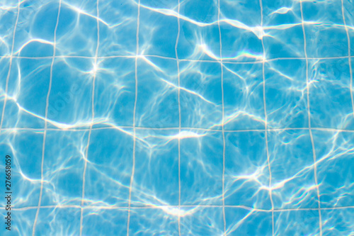 Water vibrations in the swimming pool with sun reflection. blue swimming pool surface, water background in swimming pool. Flat lay, top view