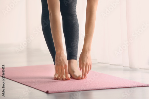 Sporty young woman practicing yoga indoors © Pixel-Shot