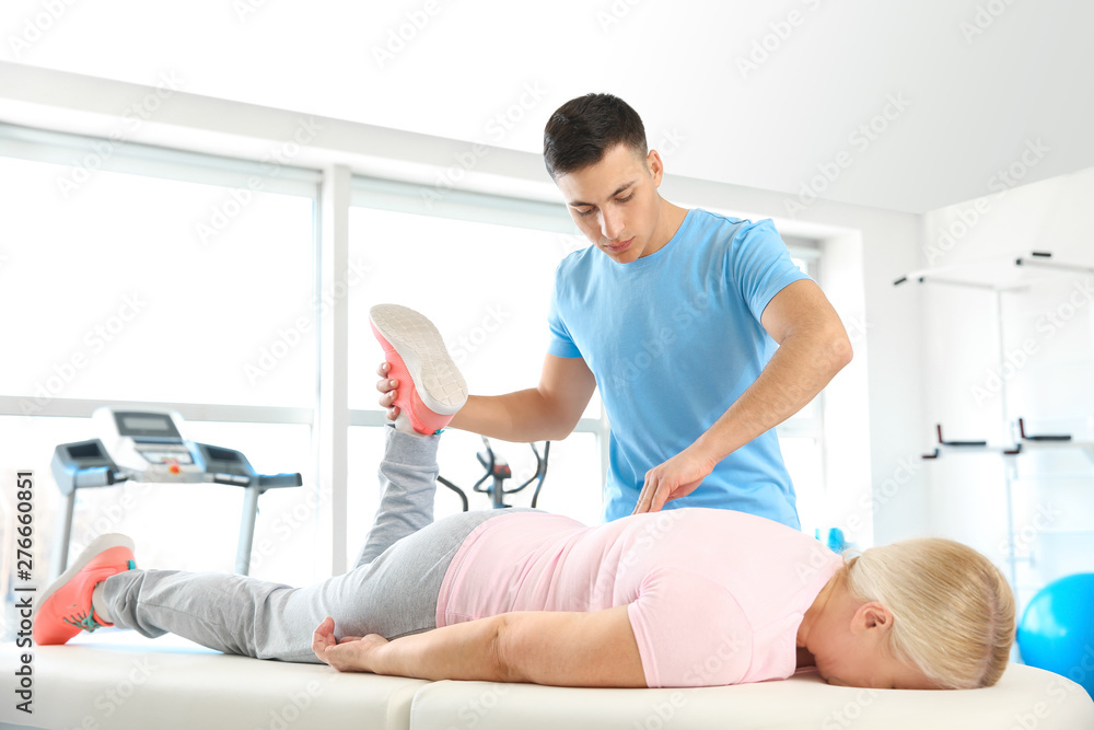Obraz premium Physiotherapist working with mature patient in rehabilitation center