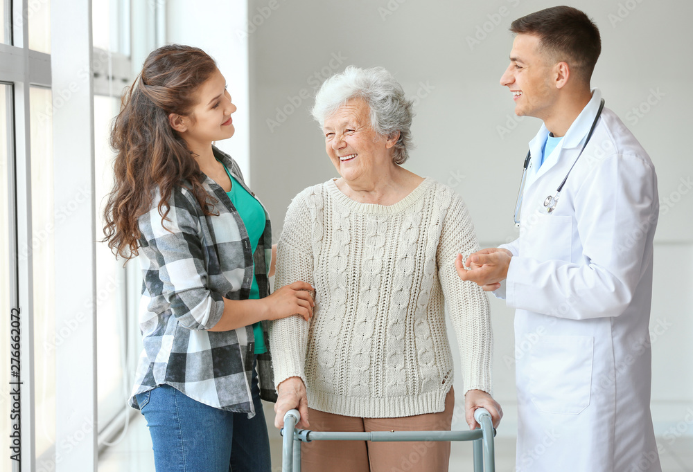 Senior woman with her granddaughter and doctor in hospital Senior woman with her granddaughter and doctor in hospital