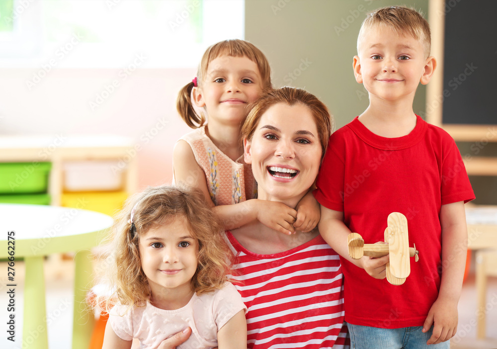 Nursery teacher with cute little children in kindergarten Nursery teacher with cute little children in kindergarten