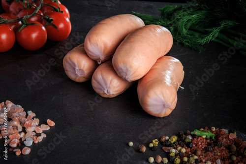 closeup heap of thick short sausages with dill and tomatoes