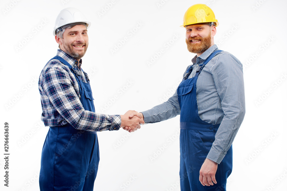 Two engineers shake hands on a white background Two engineers shake hands on a white background