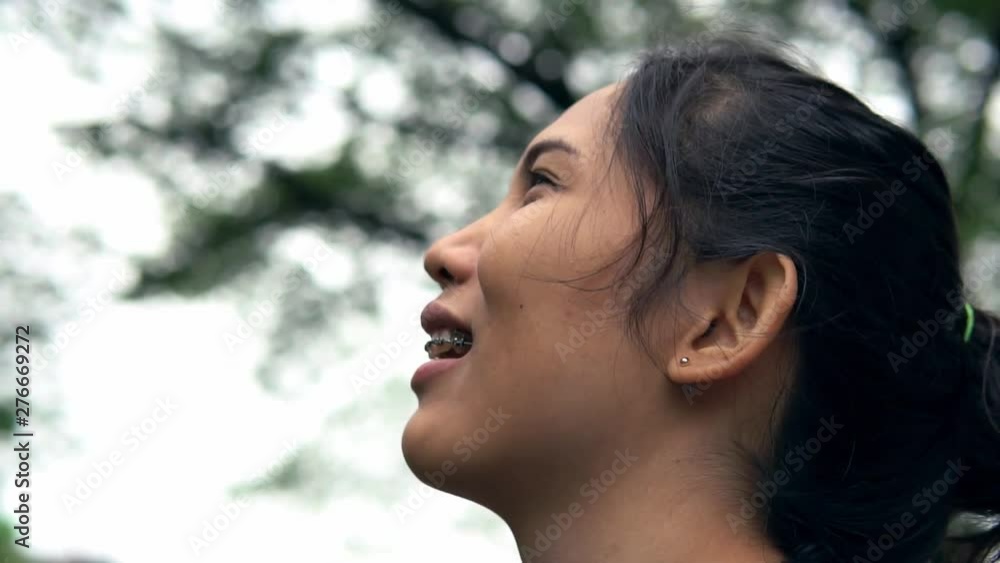 Slow motion close up face of happy woman smiling and looking on the park. Slow motion close up face of happy woman smiling and looking on the park.