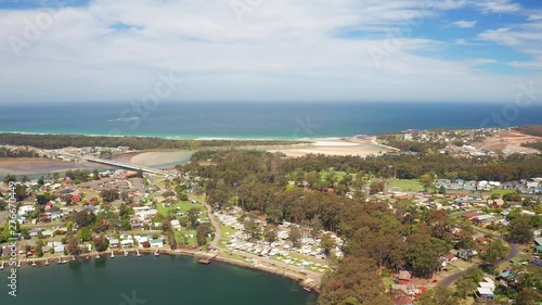 Aerial, reverse, drone shot, of beaches, the village and nature, on the coast of Burrill lake, on a sunny day, in New South Wales, Australia photo