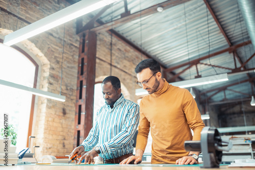 Dark-skinned graphic designer working with colleague