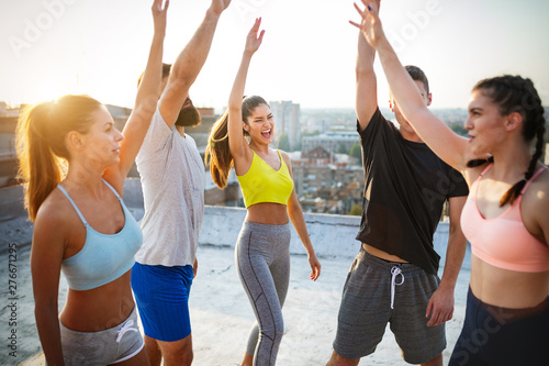 Fitness, friendship, sport and healthy lifestyle concept - group of happy friends exercising
